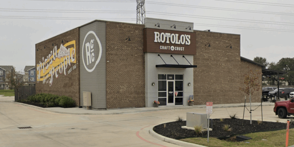 A brick Rotolo's Pizzeria with a mural and logo on a corner lot, featuring a small landscaped area and serving handcrafted pizza.